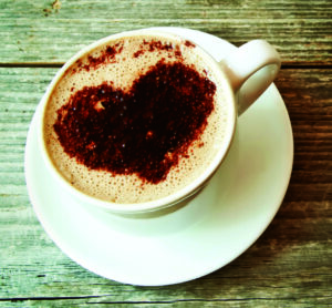 Cup of Cappuccino with Heart Shape over Wooden Background